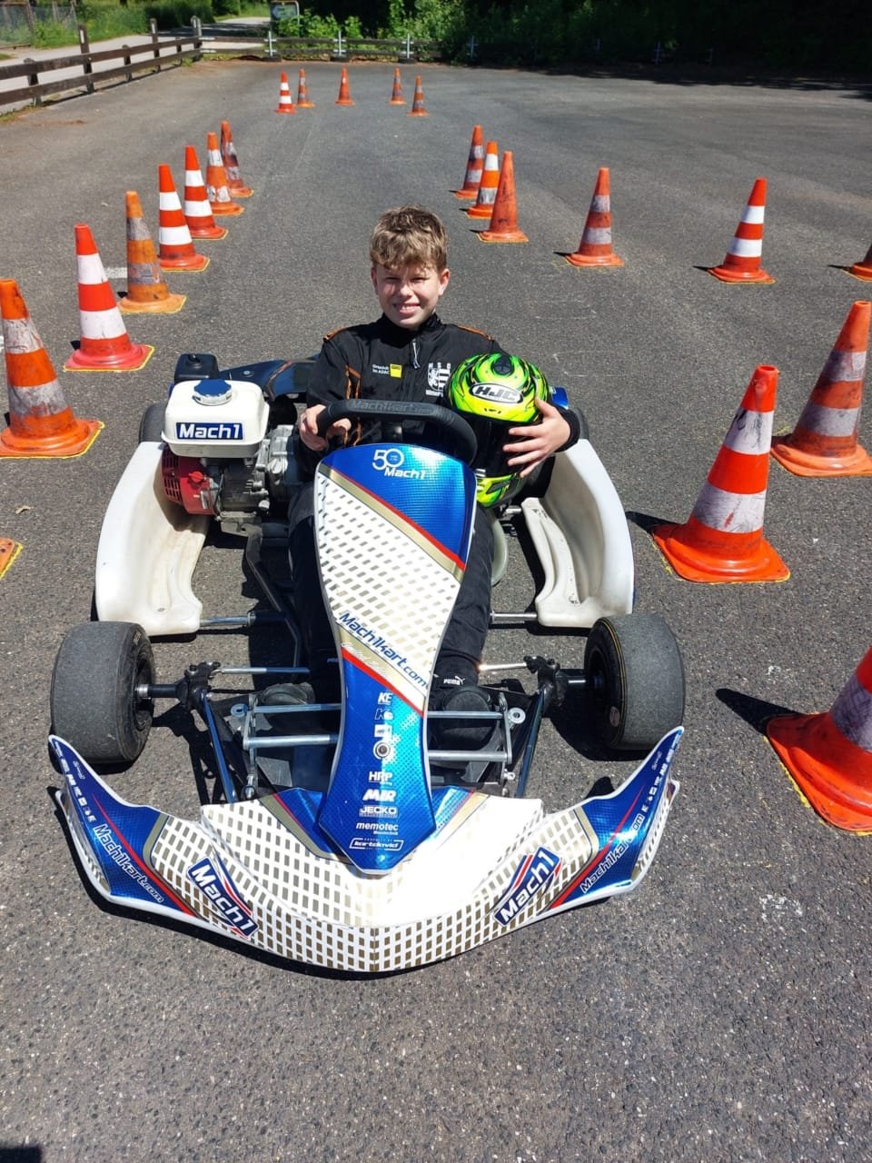 Das Bild zeigt Kevin mit Rennanzug im Kart