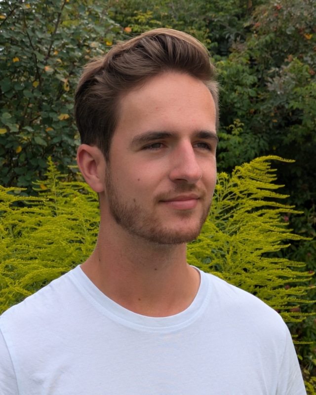 Portrait von Adrian mit Garten im Hintergrund